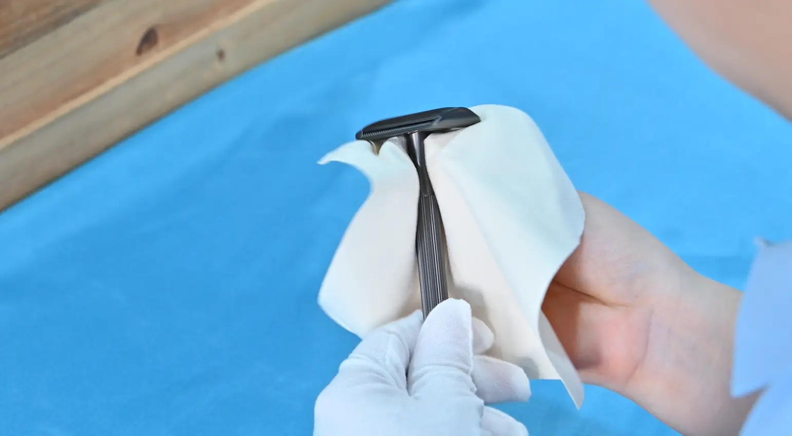 Kinghood worker cleaning a finished razor before inspection